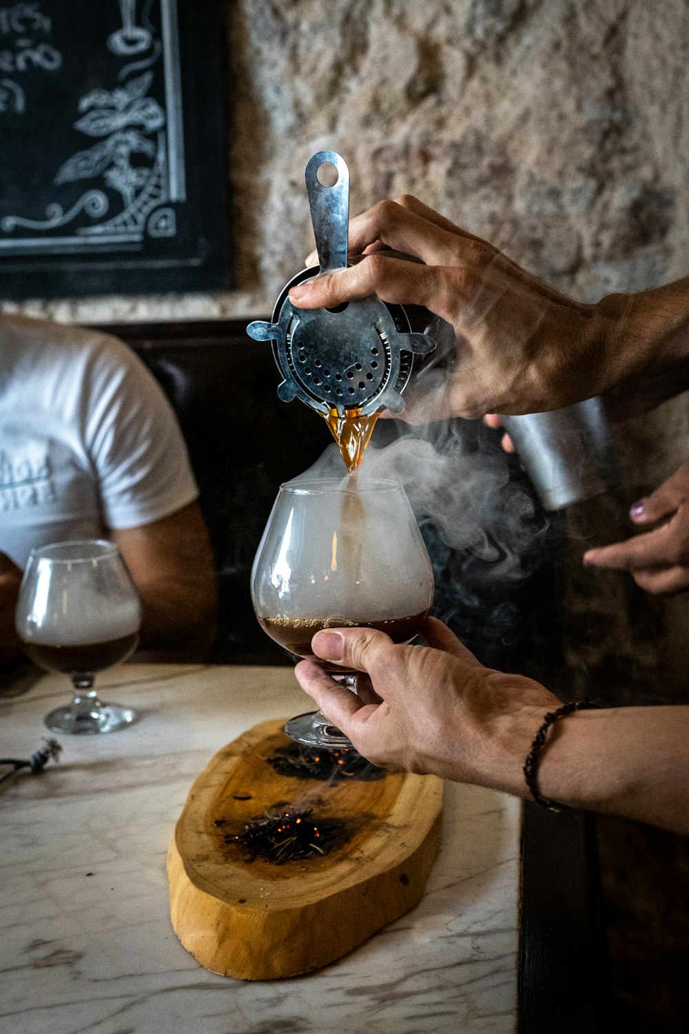 a person pours a beverage into a glass