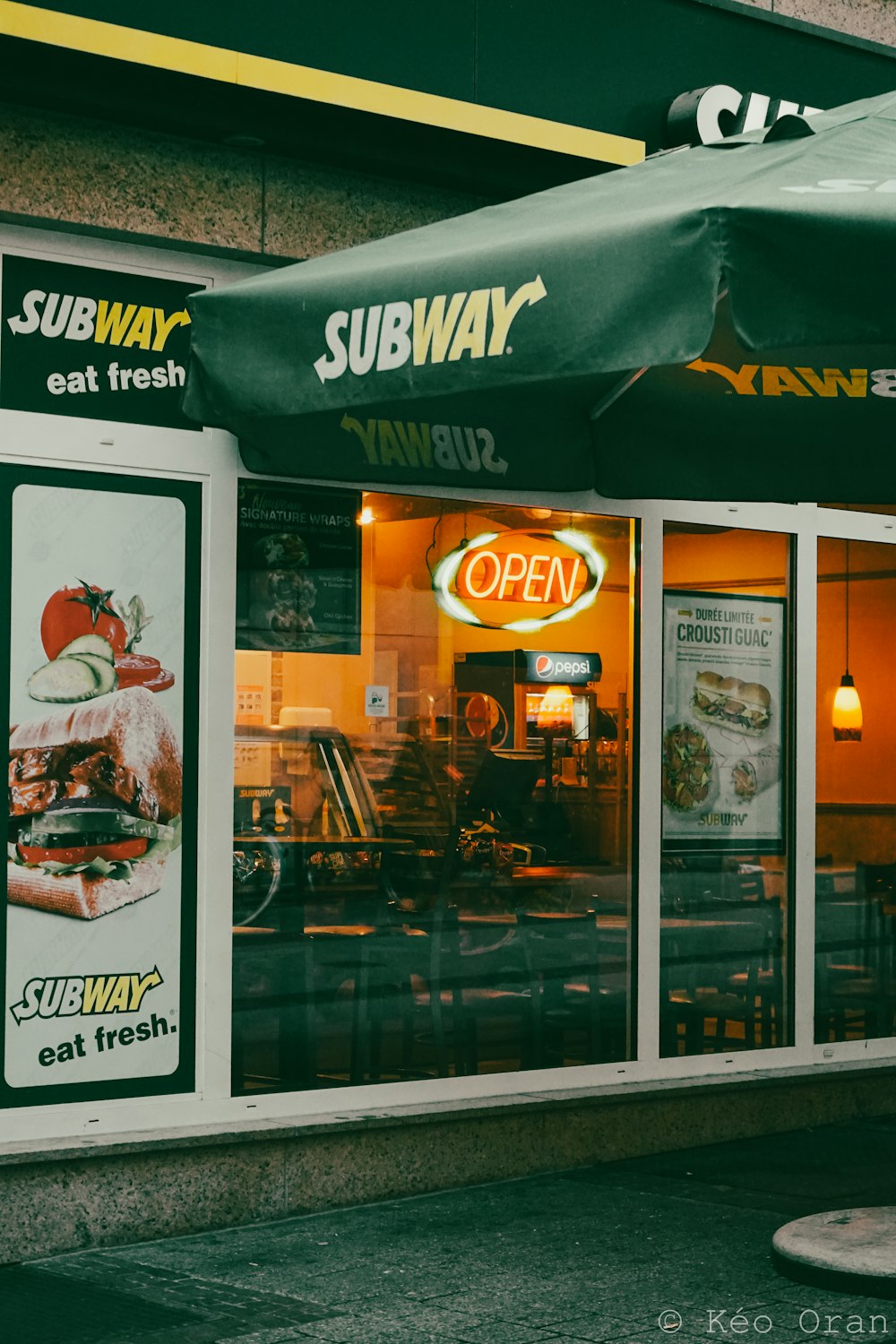 a subway restaurant with a green awning