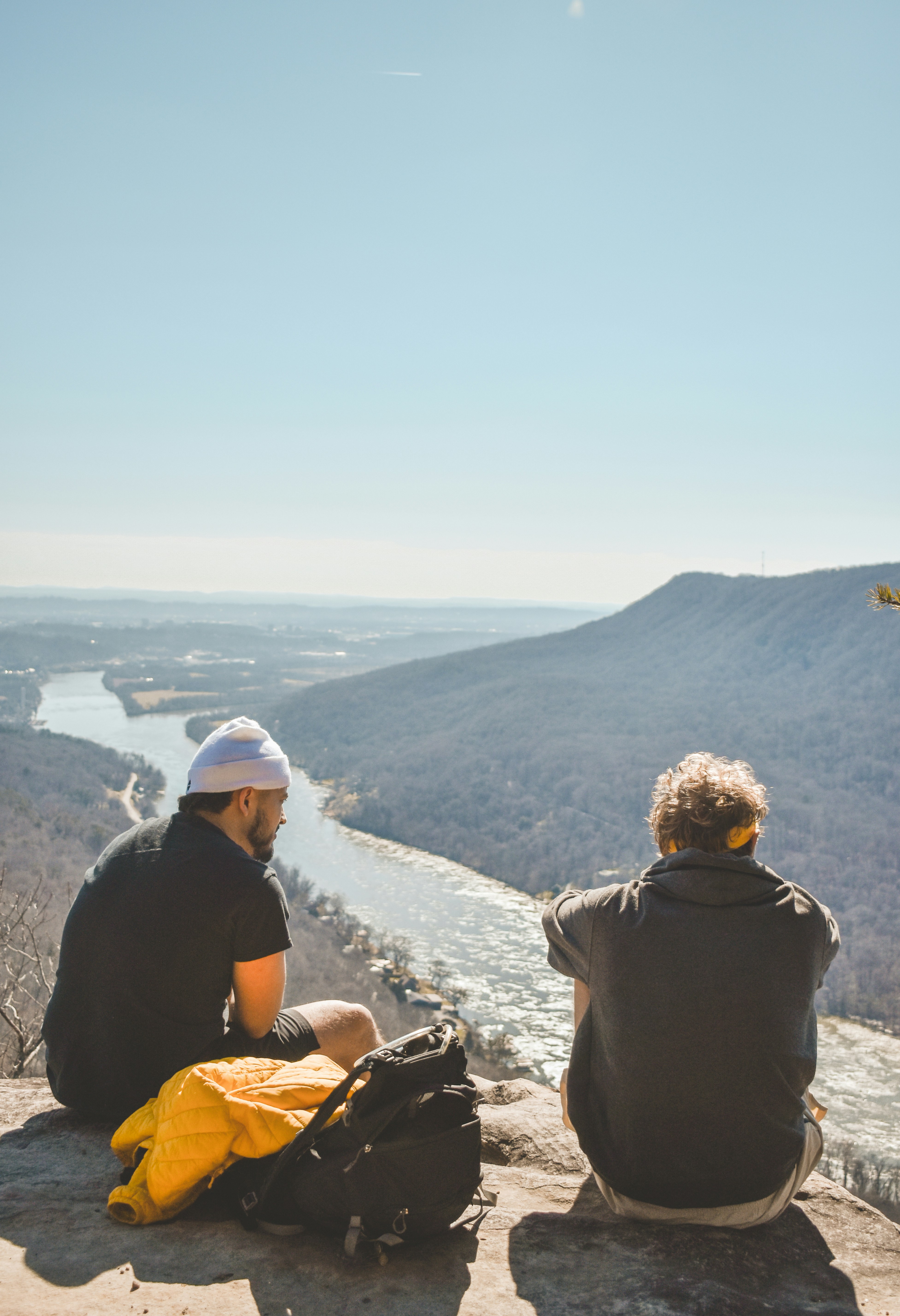 A couple of people sitting on top of a mountain photo – Free ...