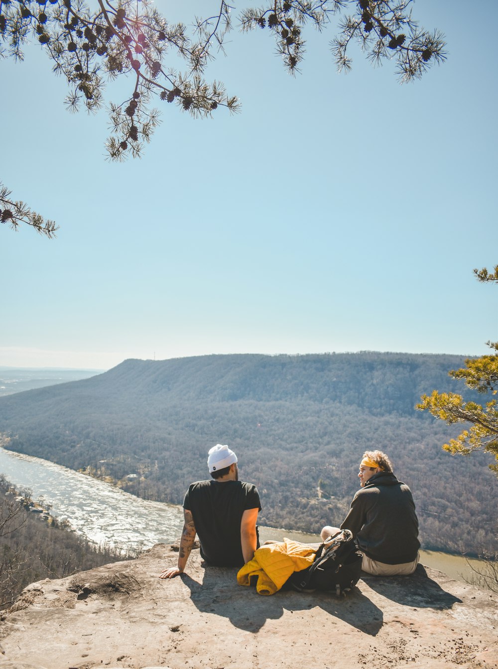 a couple of people sitting on top of a cliff