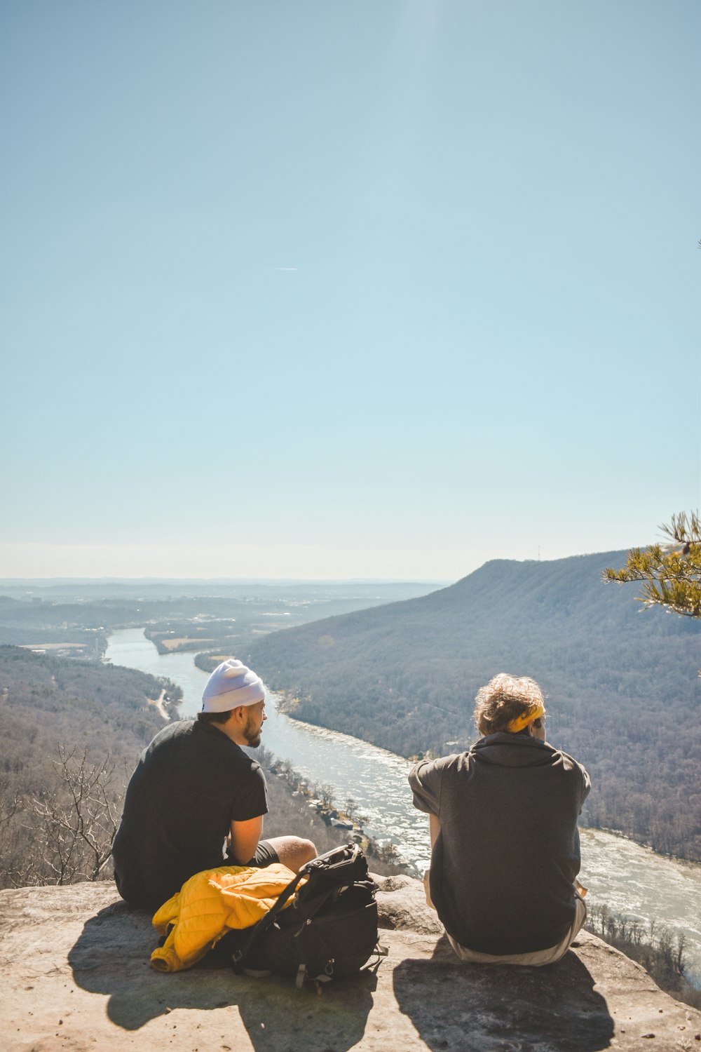 a couple of people sitting on top of a cliff