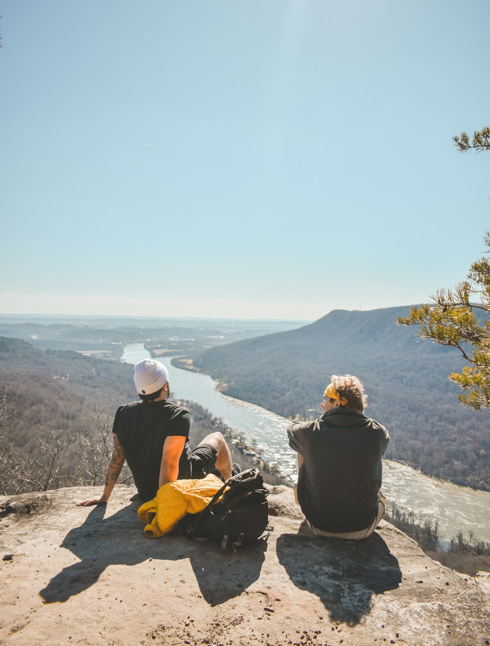 a couple of people sitting on top of a cliff