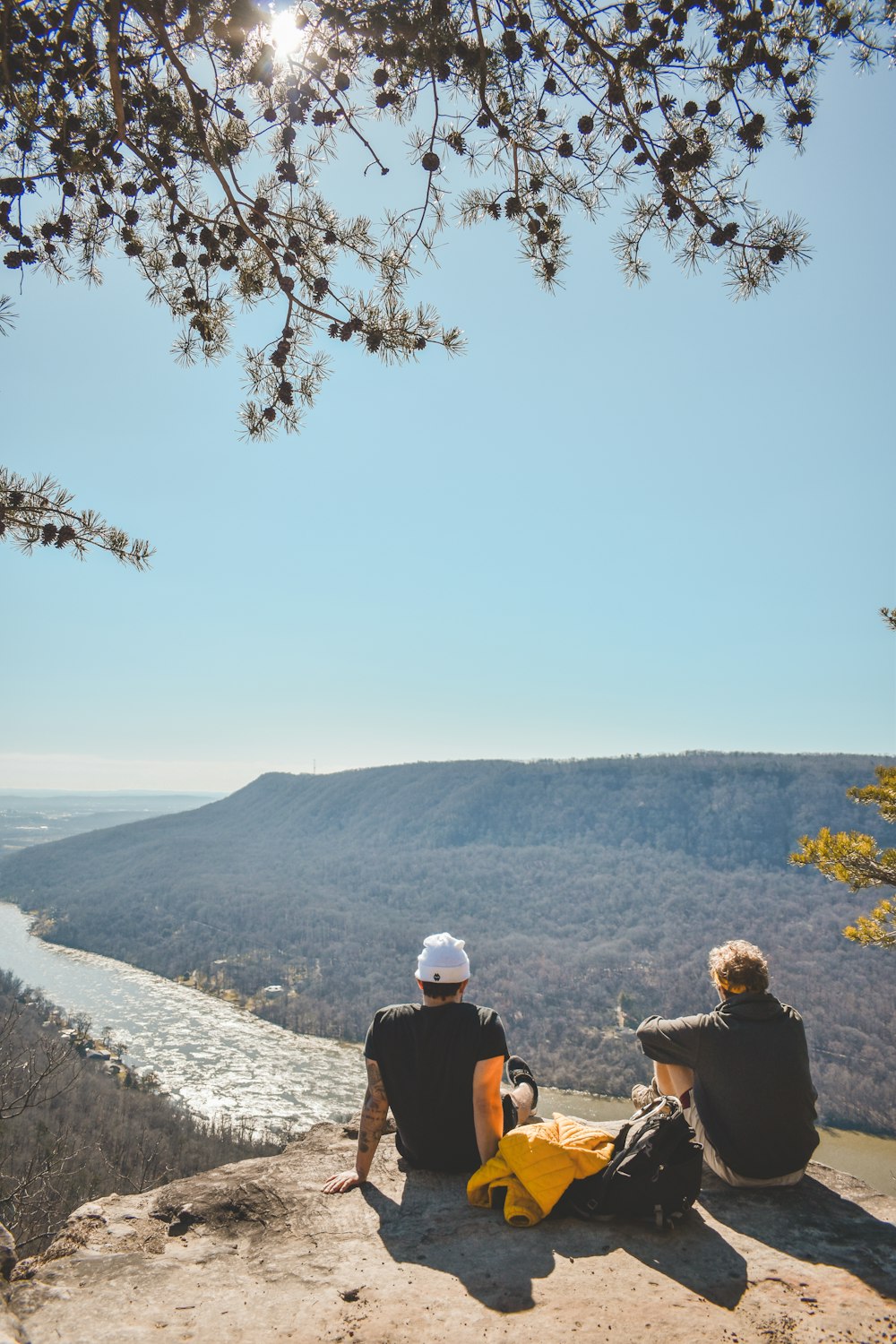 a couple of people sitting on top of a cliff