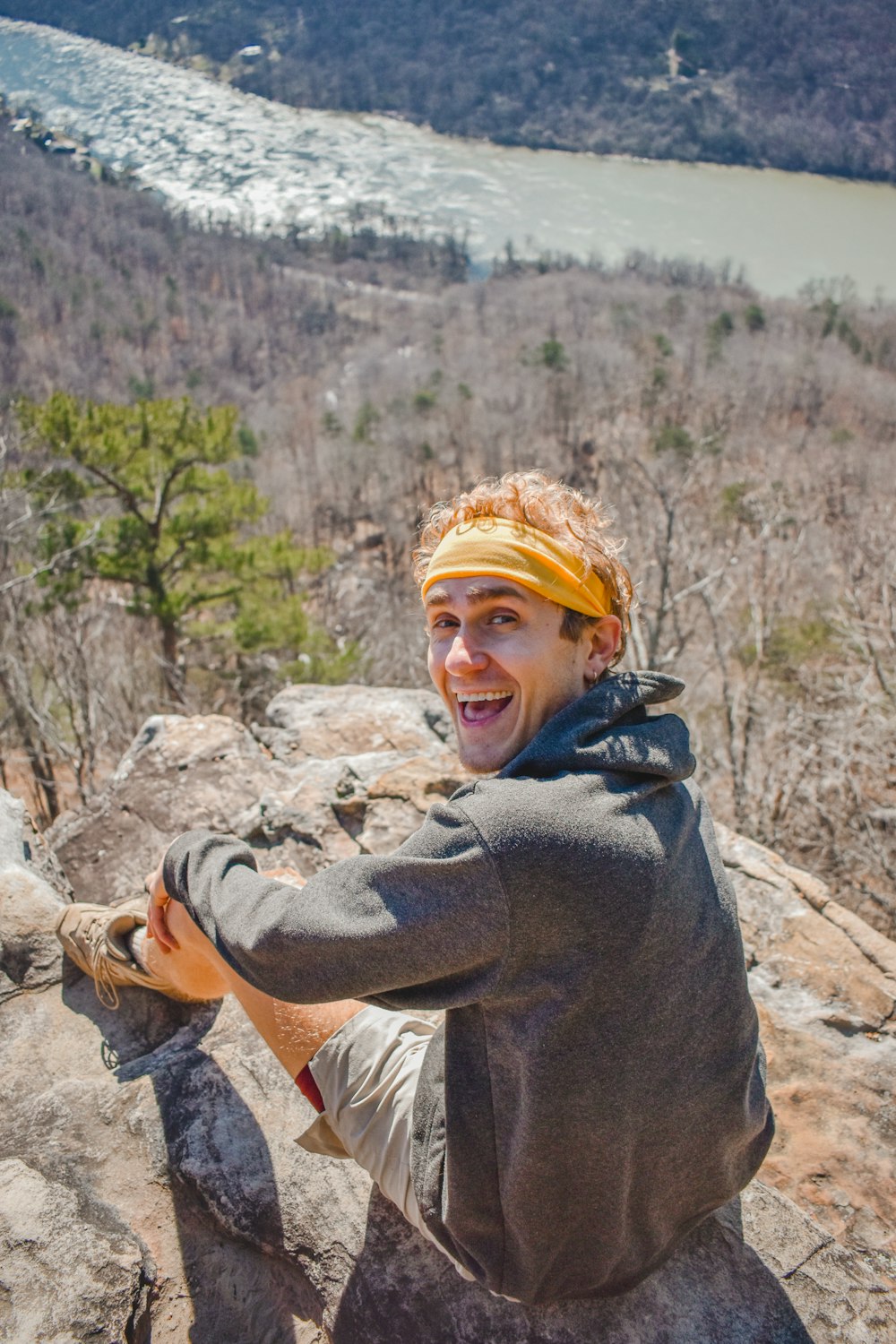 a man with a yellow bandanna on top of a mountain