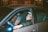 a man sitting in a car with his head out the window