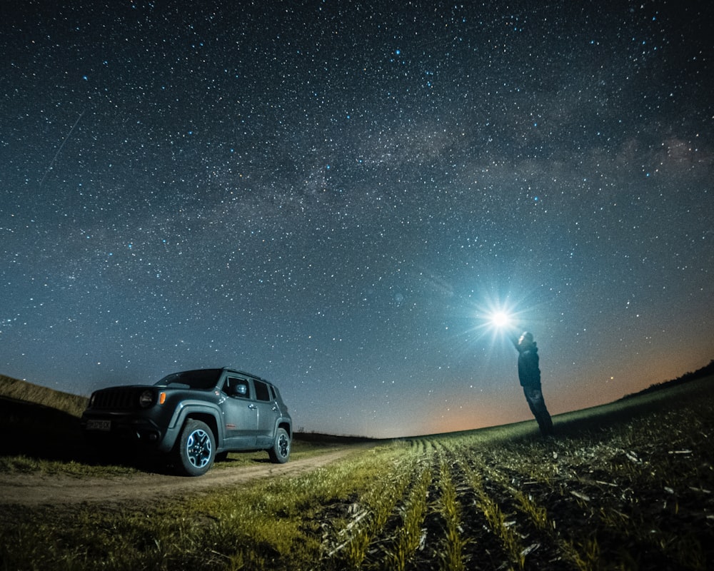 a man standing next to a truck under a night sky