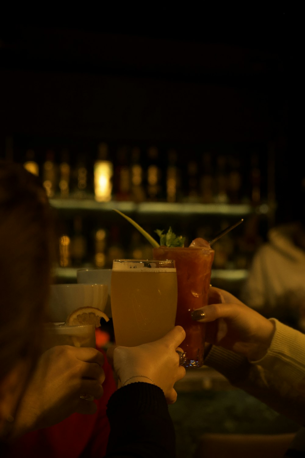 a group of people holding up drinks at a bar