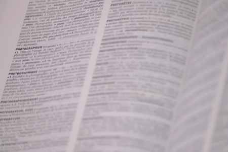 A page from a dictionary is open, displaying text in French with definitions related to photography. The text is in black and white, and the focus is on the central column with parts of the surrounding text slightly out of focus.