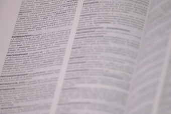 A page from a dictionary is open, displaying text in French with definitions related to photography. The text is in black and white, and the focus is on the central column with parts of the surrounding text slightly out of focus.