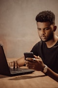 a man sitting at a table looking at his cell phone