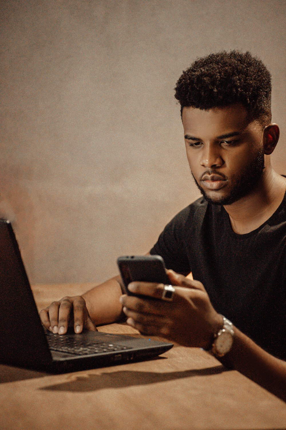 a man sitting at a table looking at his cell phone