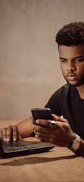 a man sitting at a table looking at his cell phone