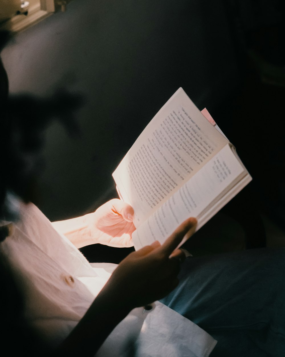 a person is reading a book in the dark
