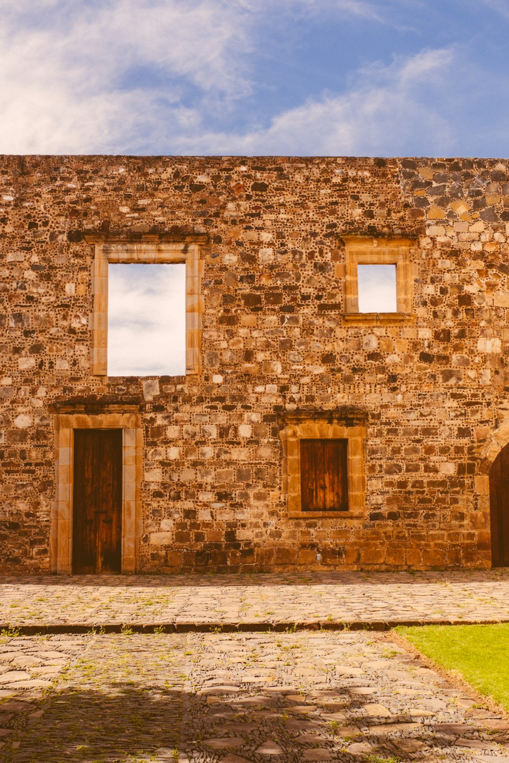 a brick building with three windows and a door