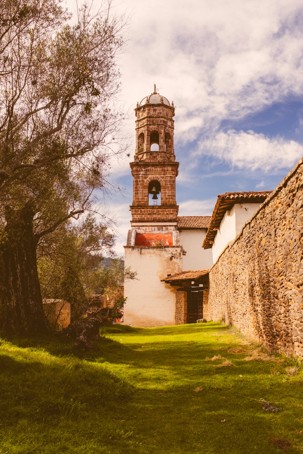 a building with a bell tower next to a tree