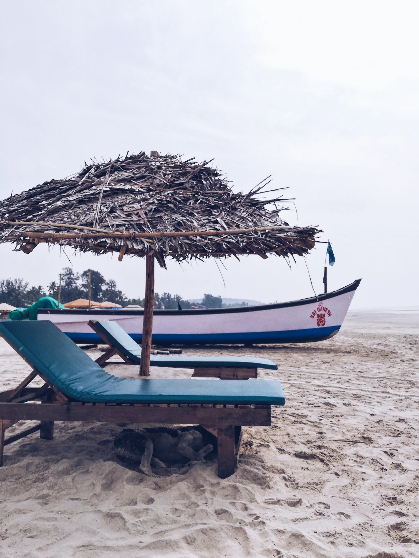 Two loungers and an umbrella on an empty Goan beach