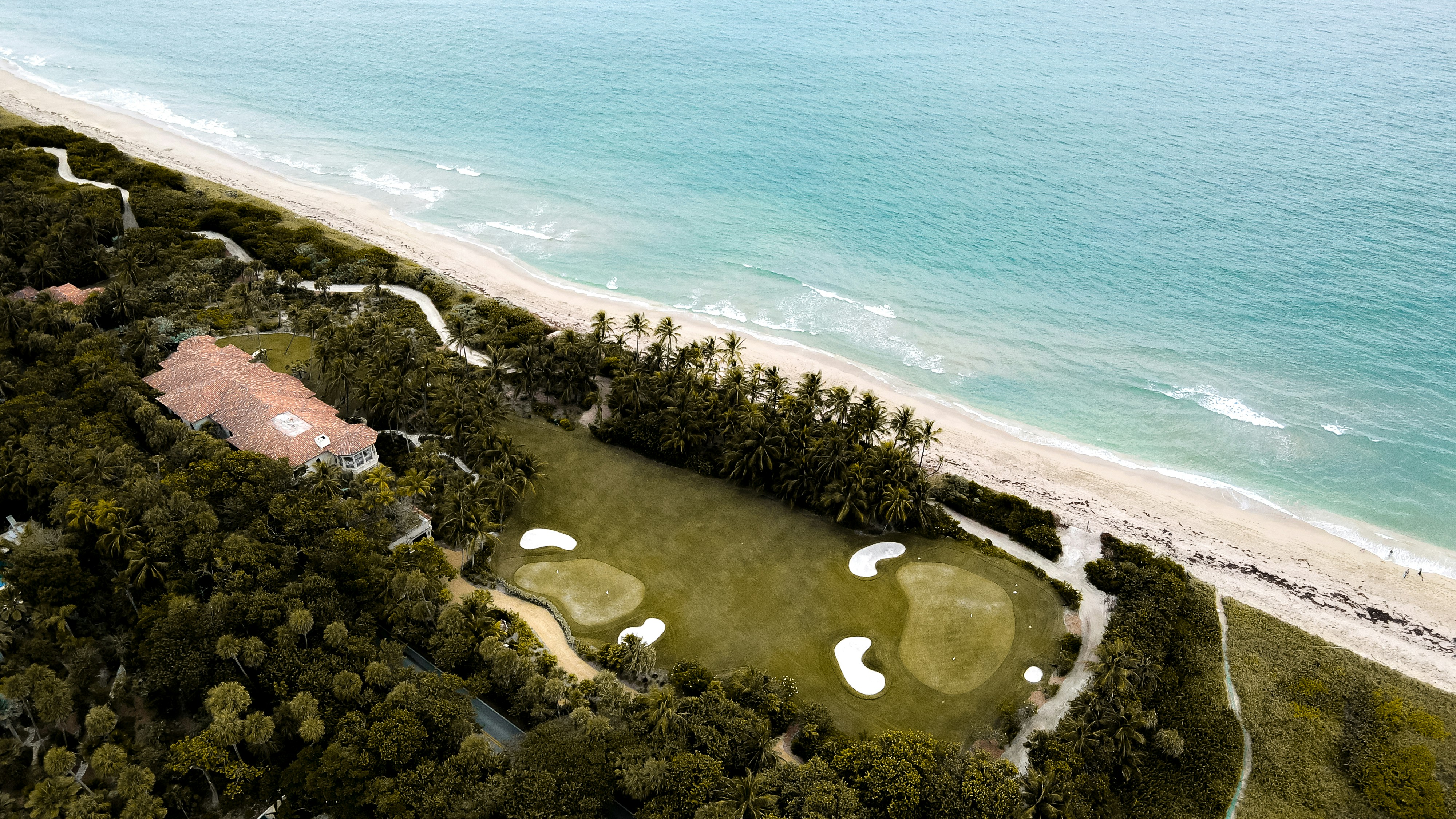 an aerial view of a golf course near the ocean
