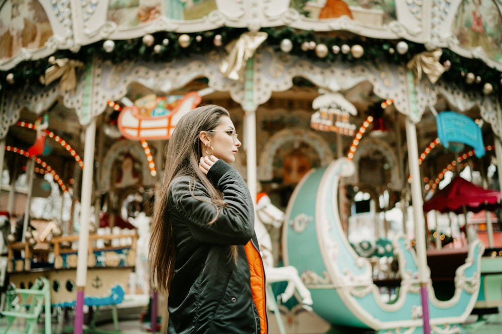 a woman standing in front of a merry go round