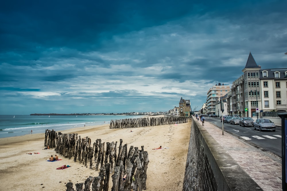 a beach with a bunch of wooden posts sticking out of the sand