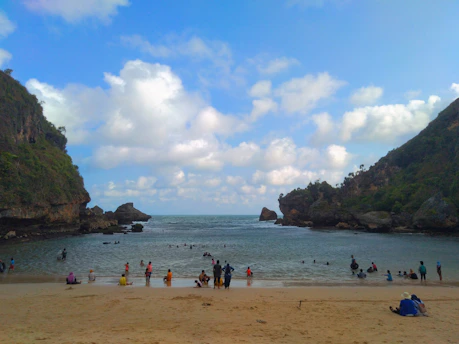 a group of people standing on top of a sandy beach