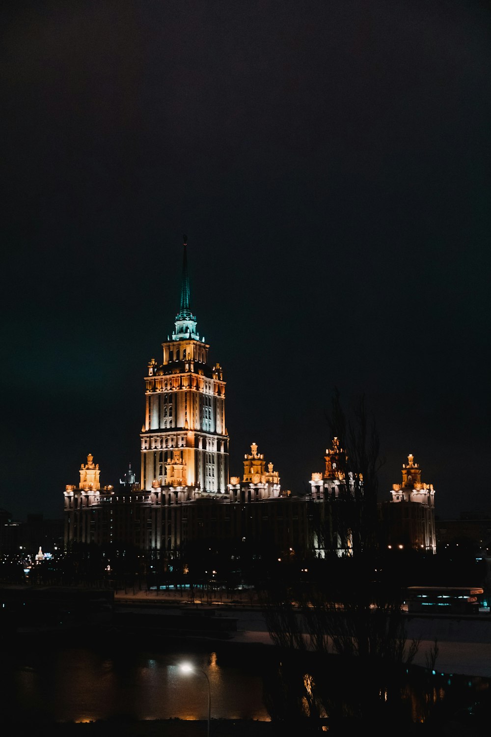 a very tall building with a green top at night