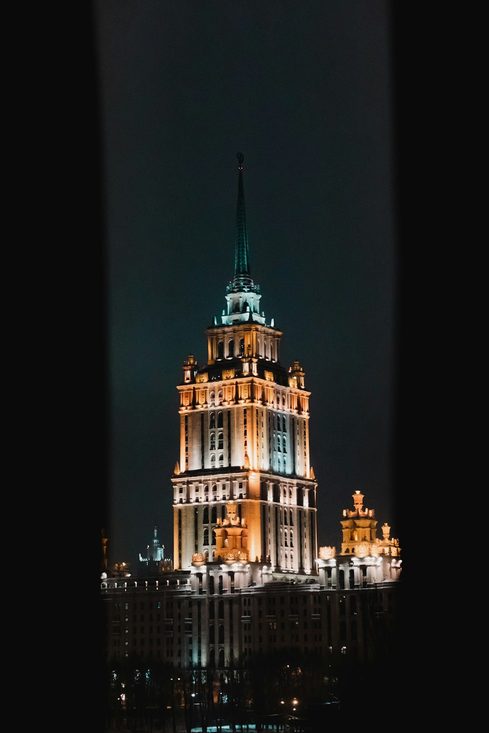 a very tall building with a spire lit up at night