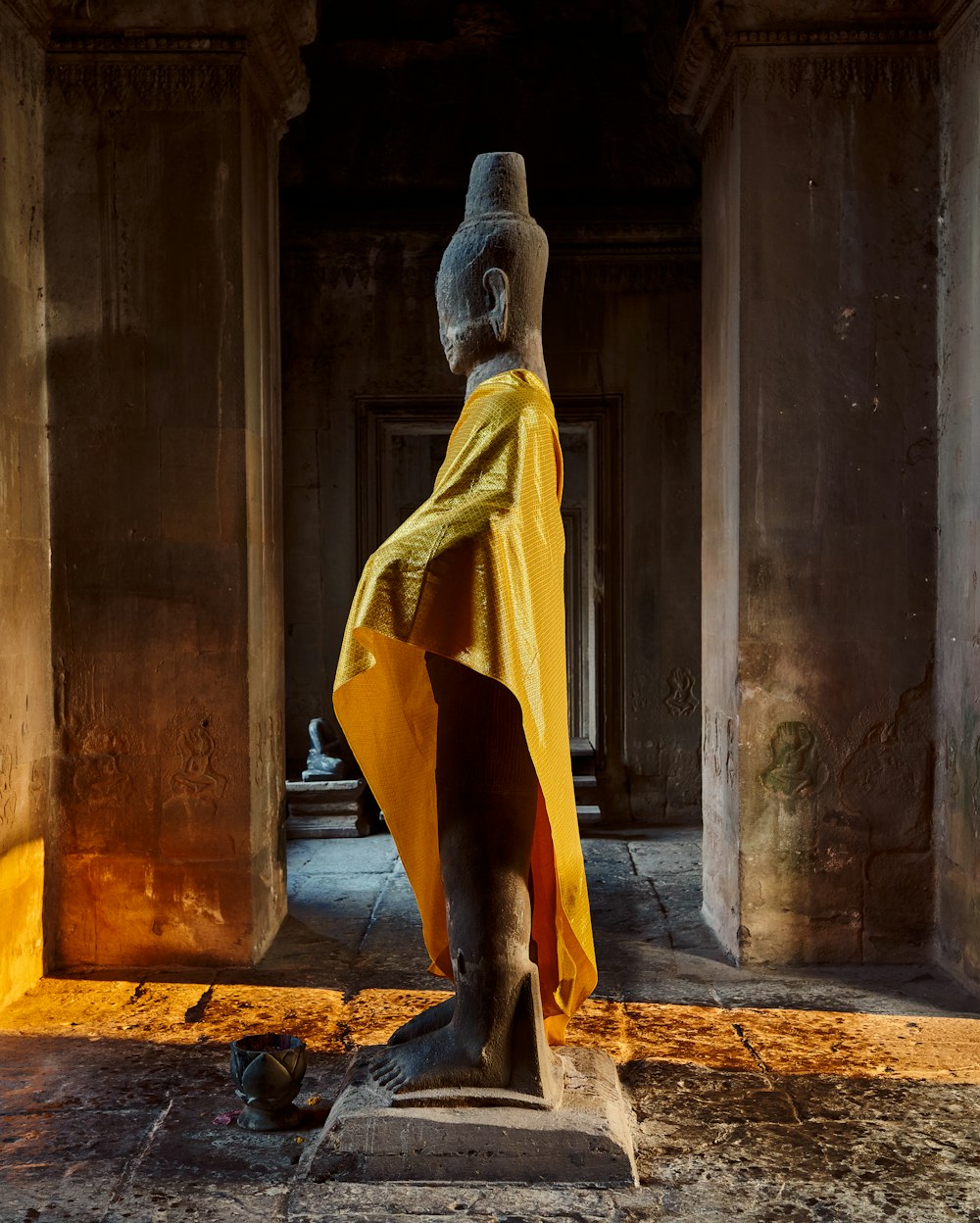 une statue d’une femme en robe jaune