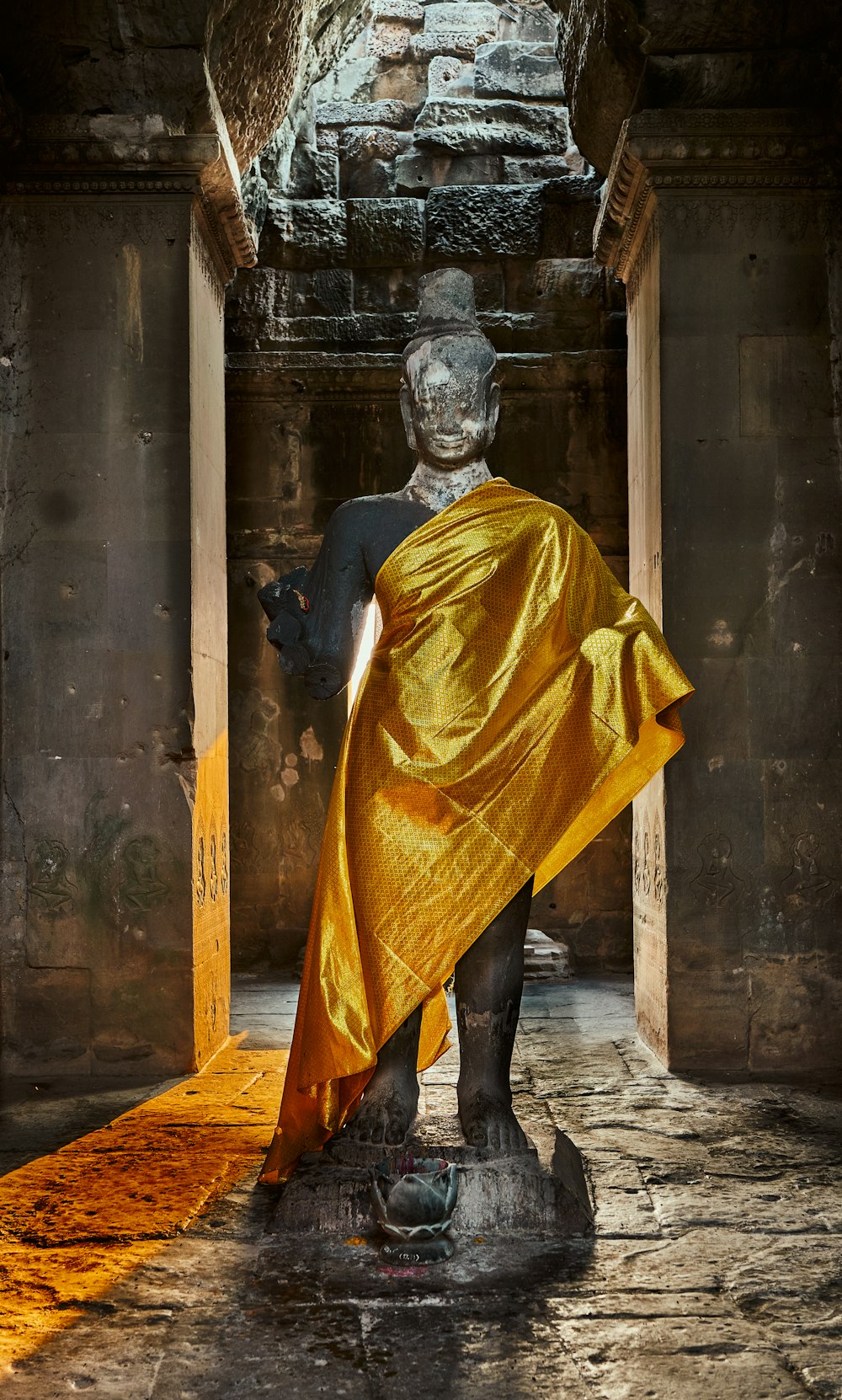 a statue with a yellow cloth draped around it