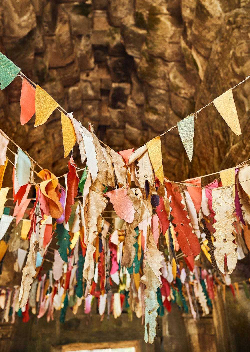 a bunch of colorful flags hanging from a ceiling