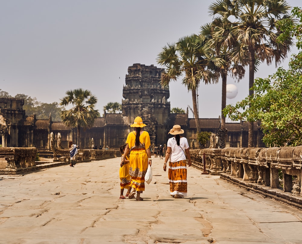 a couple of women walking across a stone walkway