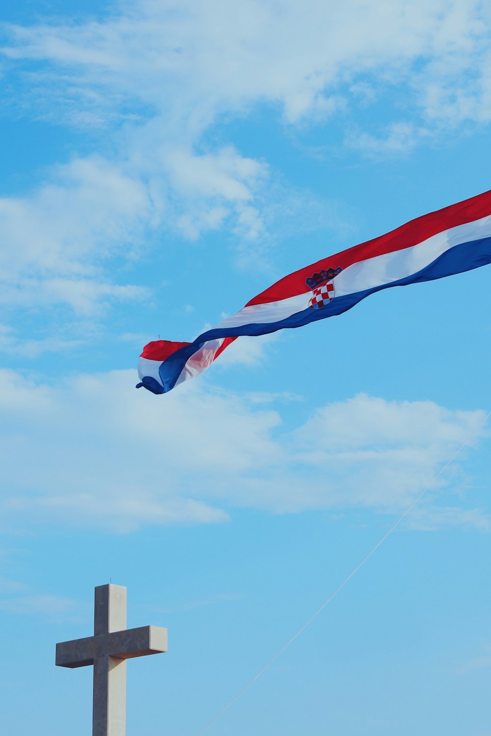 a cross and a flag flying in the sky