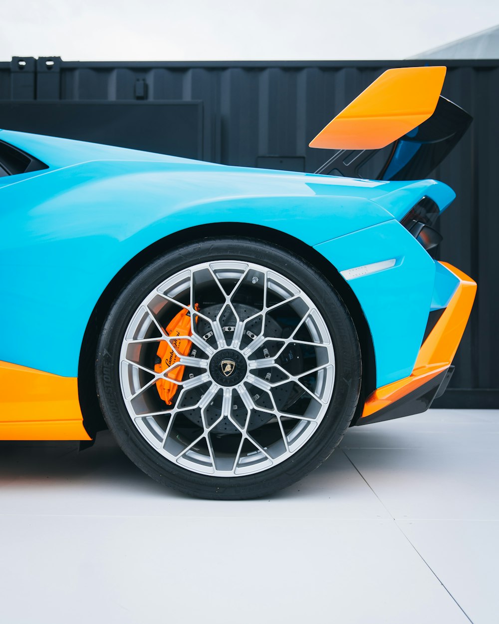um carro esportivo azul e laranja estacionado em uma garagem