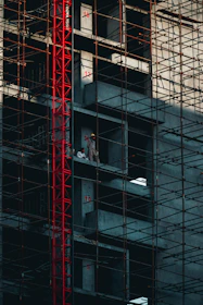 a man standing on a scaffolding in front of a tall building