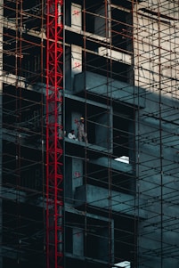 a man standing on a scaffolding in front of a tall building