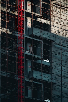 a man standing on a scaffolding in front of a tall building