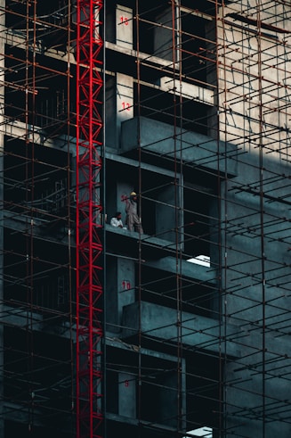 a man standing on a scaffolding in front of a tall building