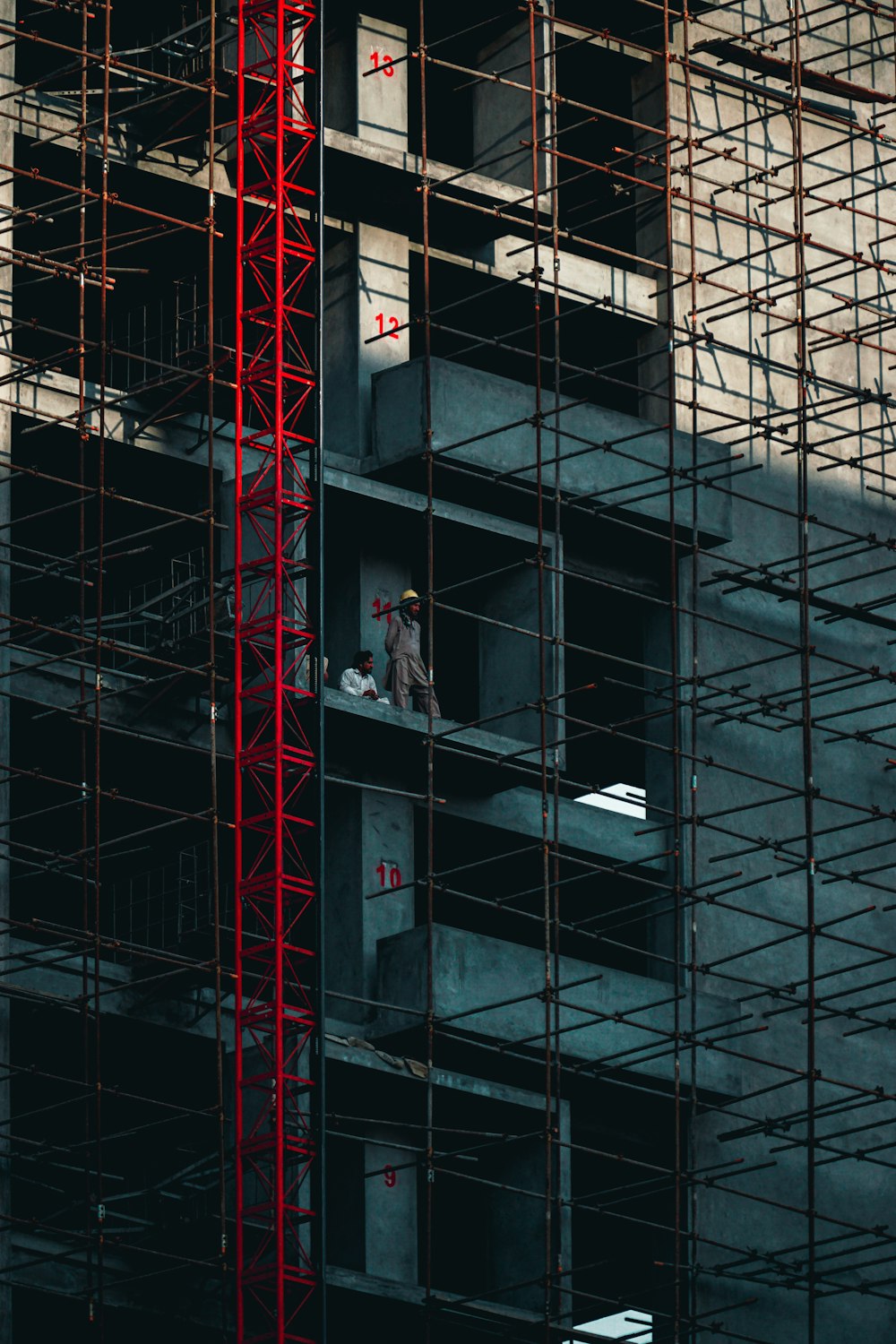 um homem de pé em um andaime em frente a um edifício alto