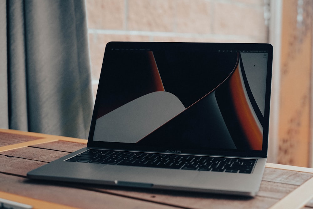 a laptop computer sitting on top of a wooden table