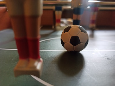Close-up of hands playing a classic foosball game with intense focus.