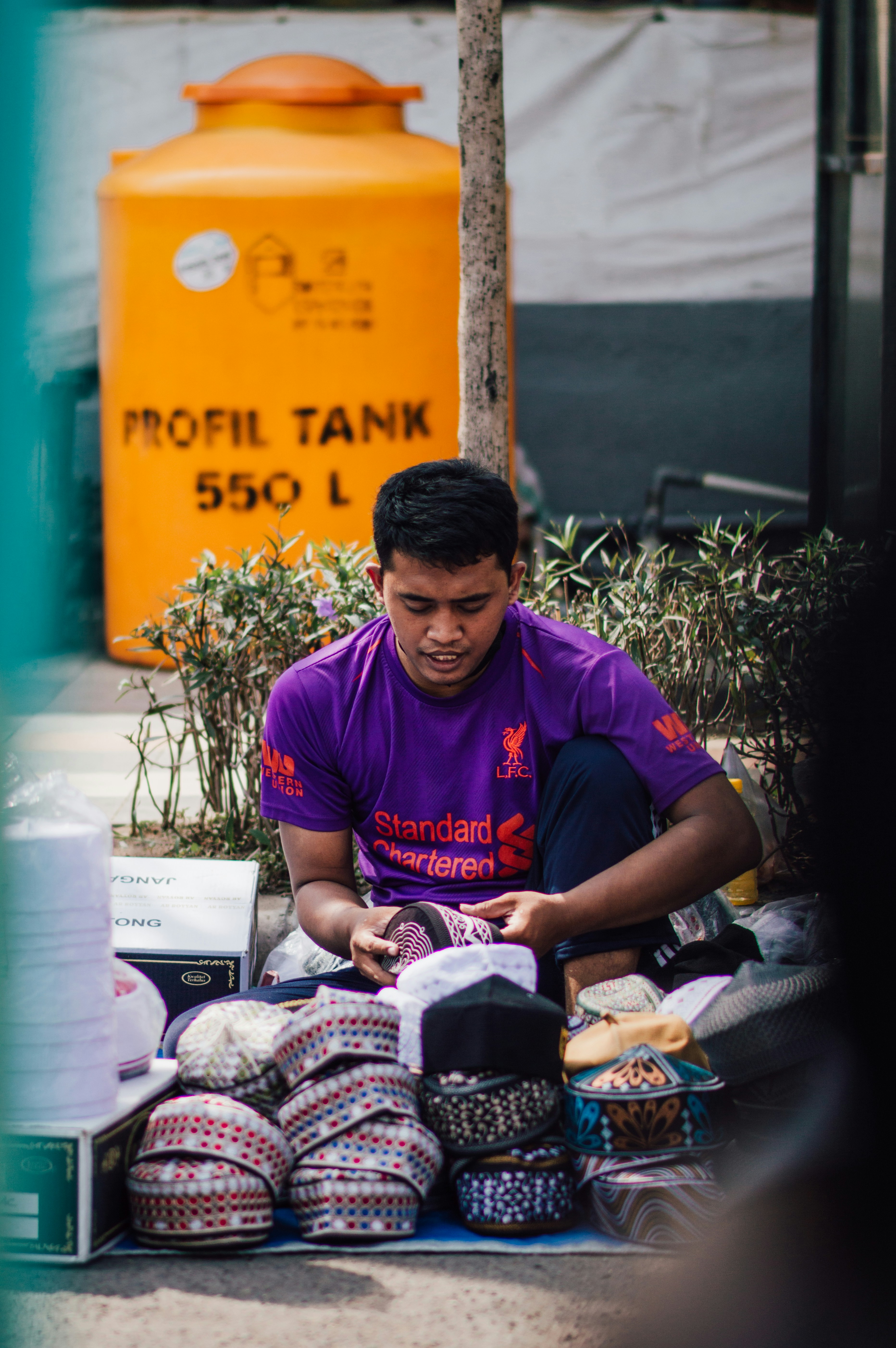 a man sitting on the ground looking at his cell phone