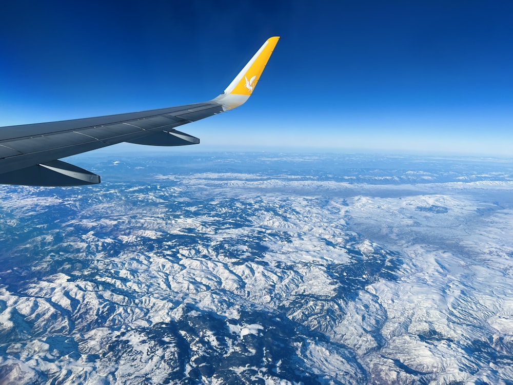 the wing of a plane flying over a mountain range