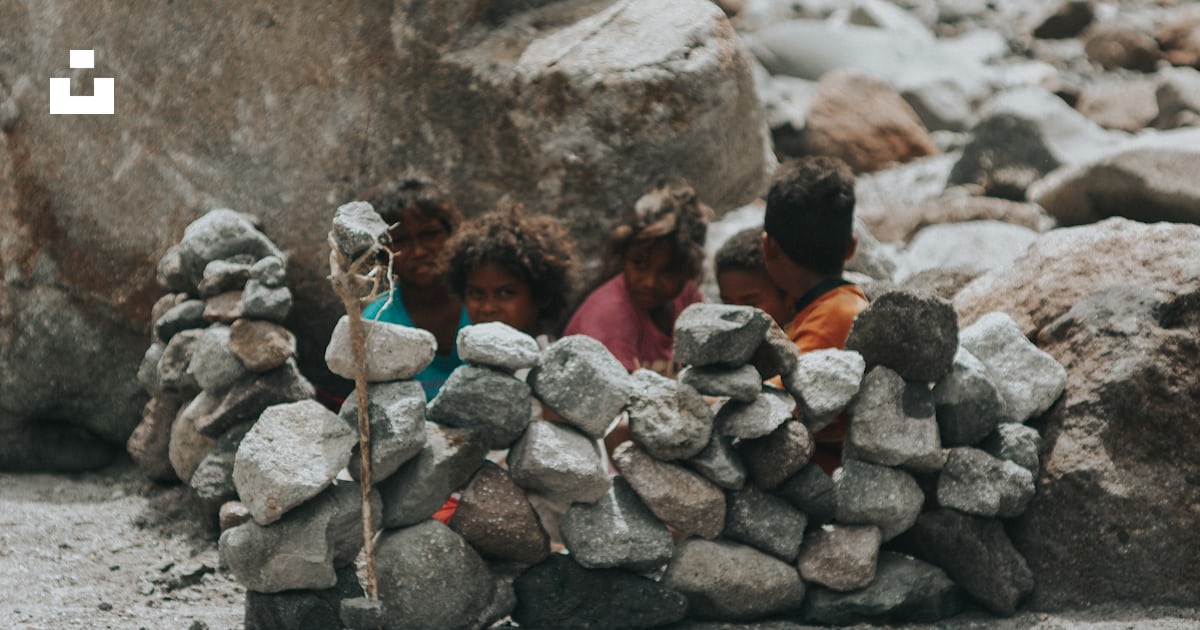 A group of children playing around a pile of rocks photo – Free Mt ...