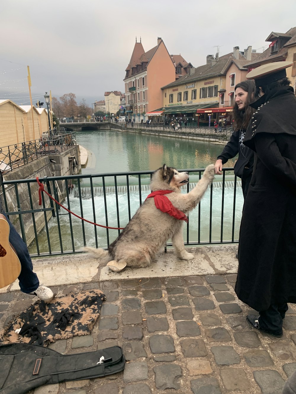 a man and a woman petting a dog on a leash