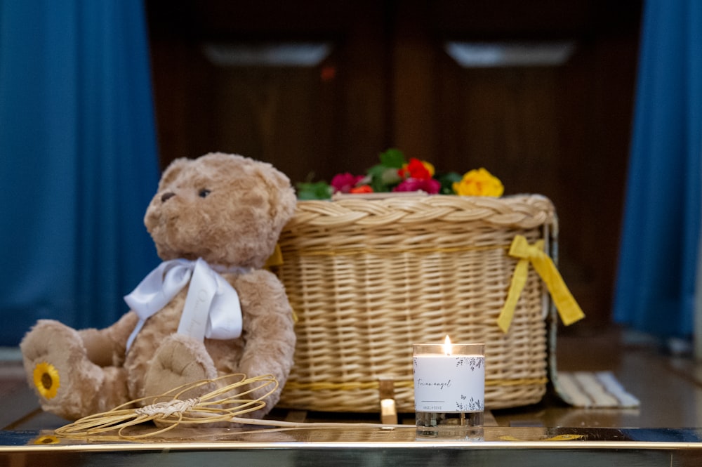 a teddy bear sitting next to a basket of flowers