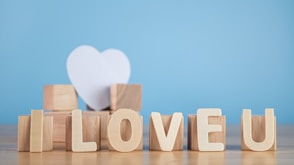 a wooden block spelling i love u with a white heart