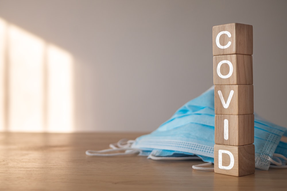 a wooden block with the word covid written on it