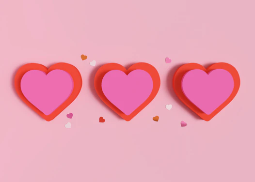 three red hearts with confetti on a pink background