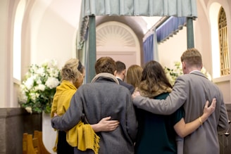 a group of people standing in front of a coffin in a church