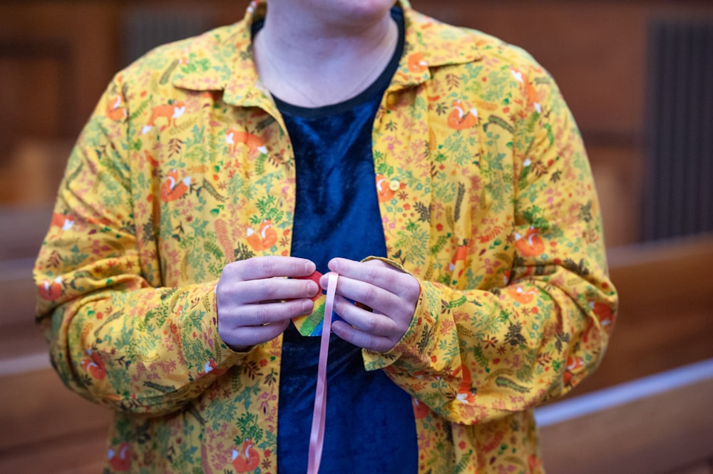 a woman in a yellow jacket is holding a string