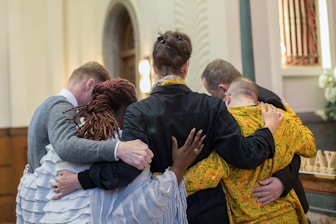 a group of people hugging each other in a church